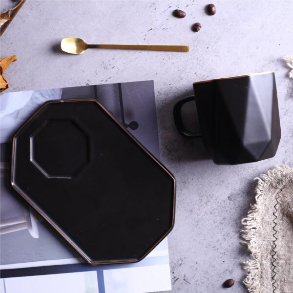 Geometric ceramic mug with gold accents and saucer.