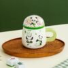 Panda-themed ceramic coffee mug with lid, perfect for office or home.