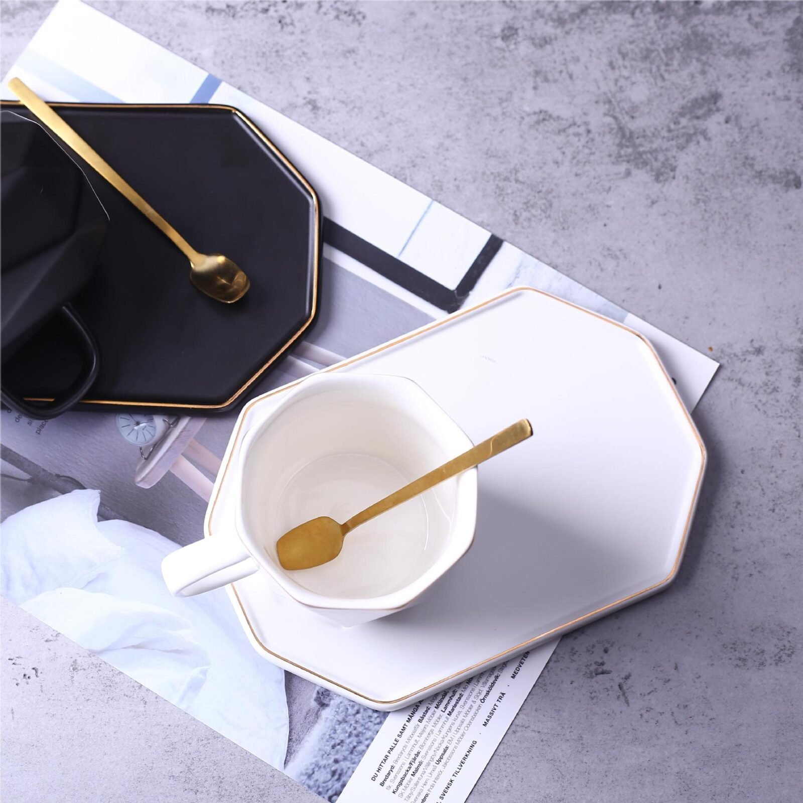 Gilded ceramic coffee mug with saucer, geometric design.