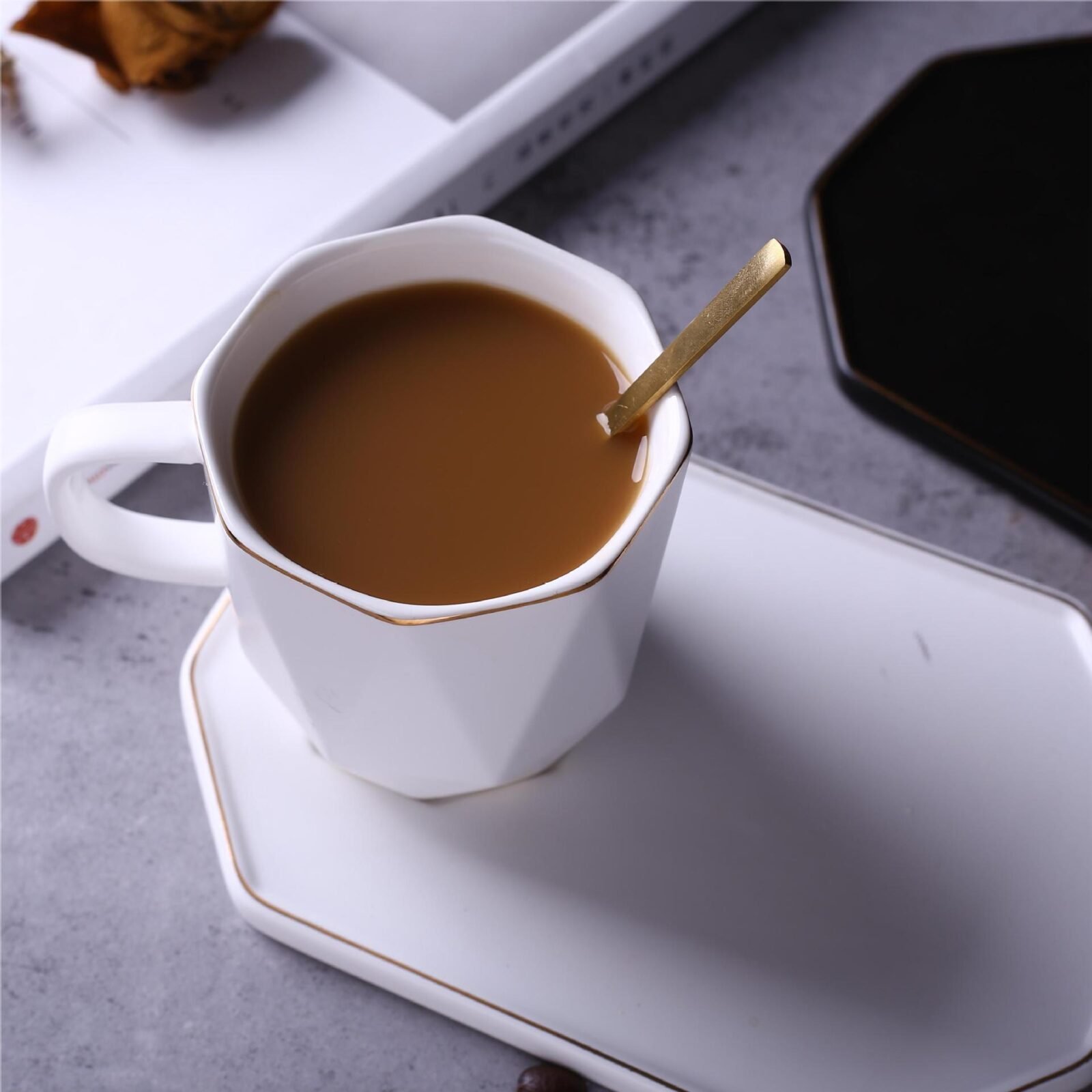 Geometric ceramic tea cup and saucer with gold detailing.